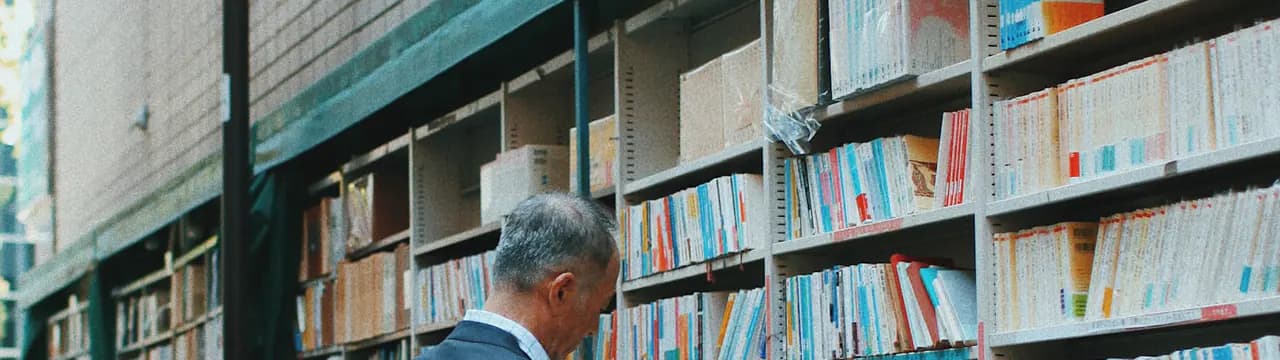 A person looking at books in a street shop