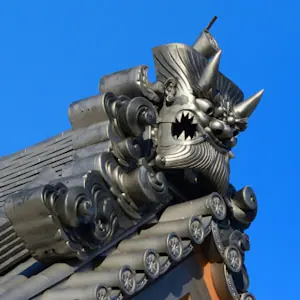 Onigawara (demon-headed roof tile) mounted on the peak of a temple roof, Toyonaka, Osaka.