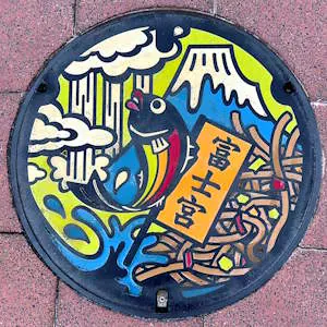 Lacquered manhole cover depicting Mount Fuji, waterfalls, and other Fujinomiya attractions.