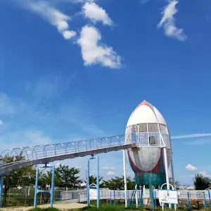 View of children's playground featuring a rugby ball-shaped slide.
