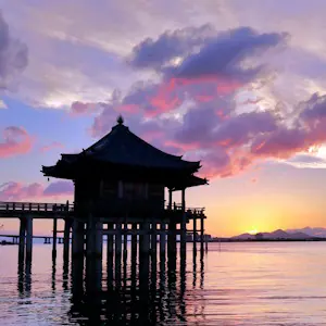 View of sunset over Lake Biwa showing Mangetsu-ji's "Floating Temple" hall, Otsu, Shiga.