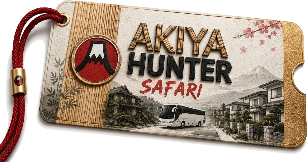 A bamboo and linen luggage tag on a red cord reading Akiya Hunter Safari, with a Mount Fuji roundel, a bus and Japanese houses